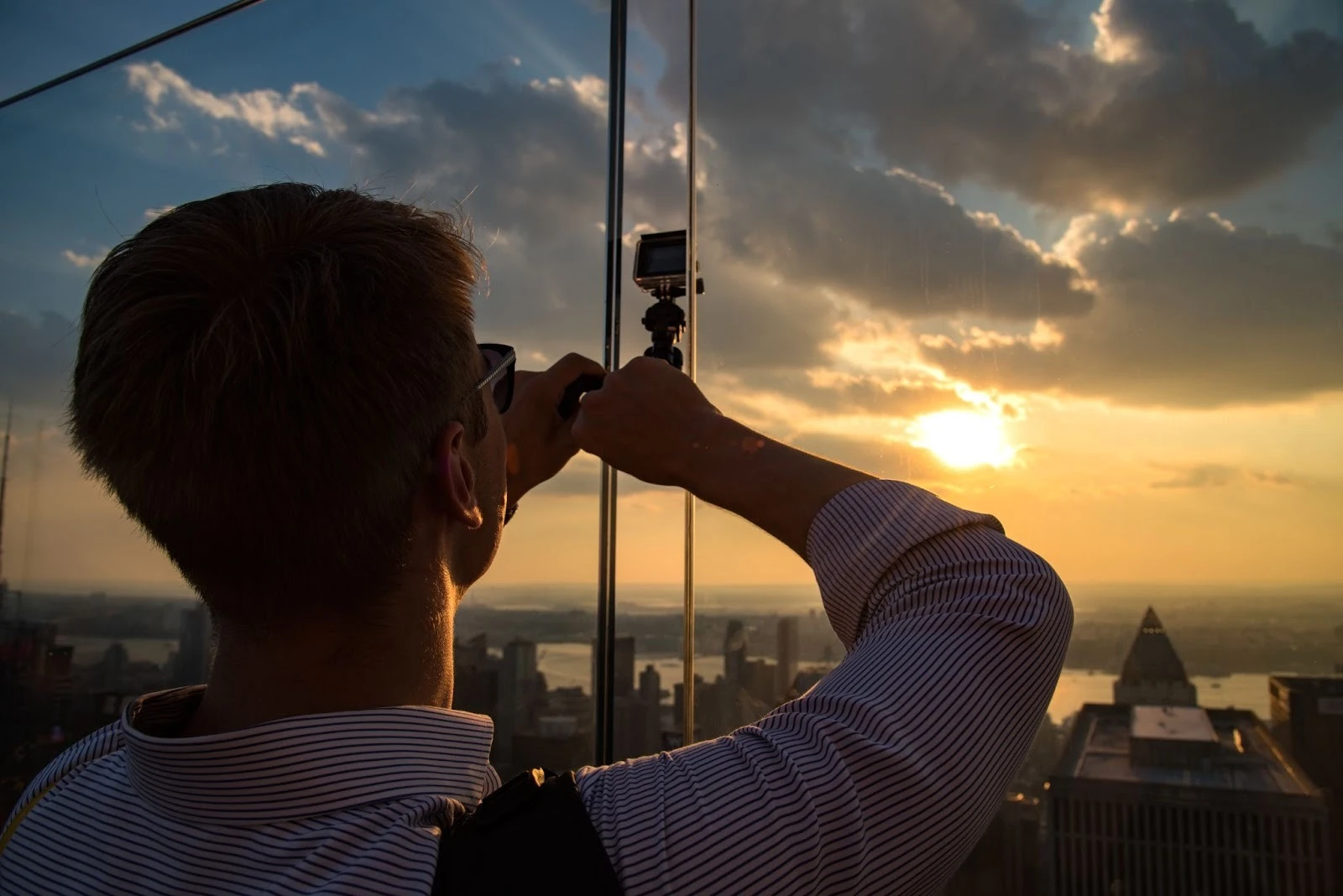 A man taking a picture on a GoPro Camera from a viewing point