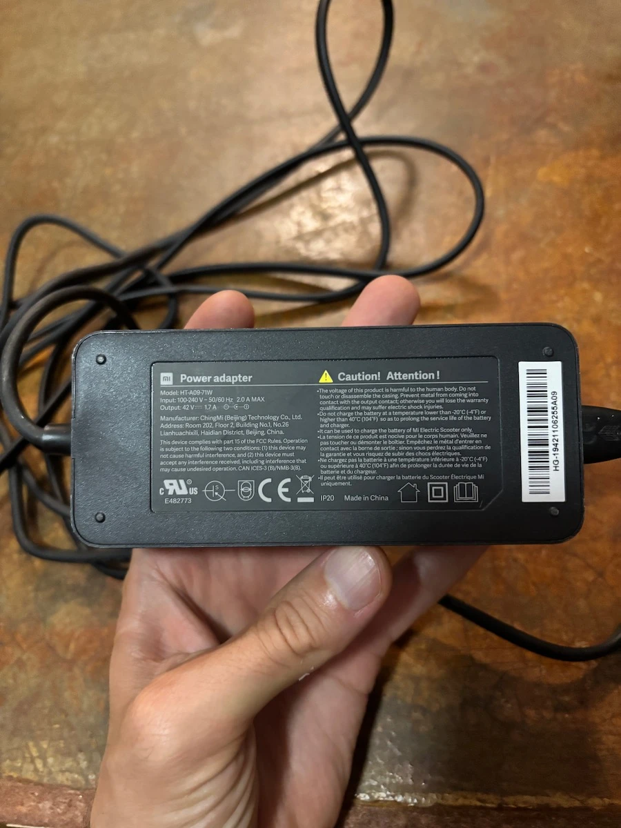 Оригінальна зарядка для електросамоката Xiaomi M365 на білому фоні