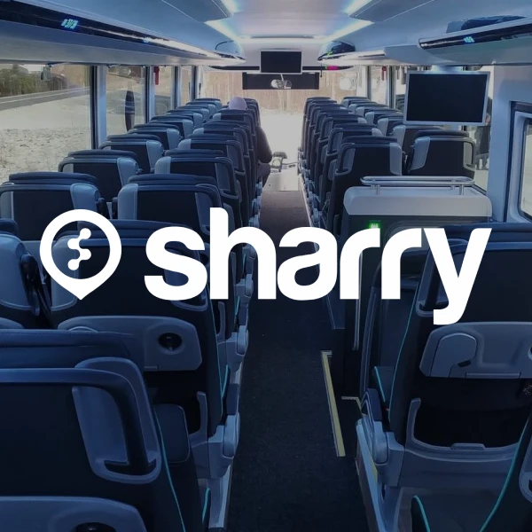 логотип і назва компанії Sharry на фоні порожнього синього салону автобусу