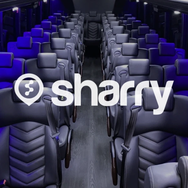 логотип і назва компанії Sharry на фоні пустого шкіряного чорного салону автобусу із синьою підсвіткою