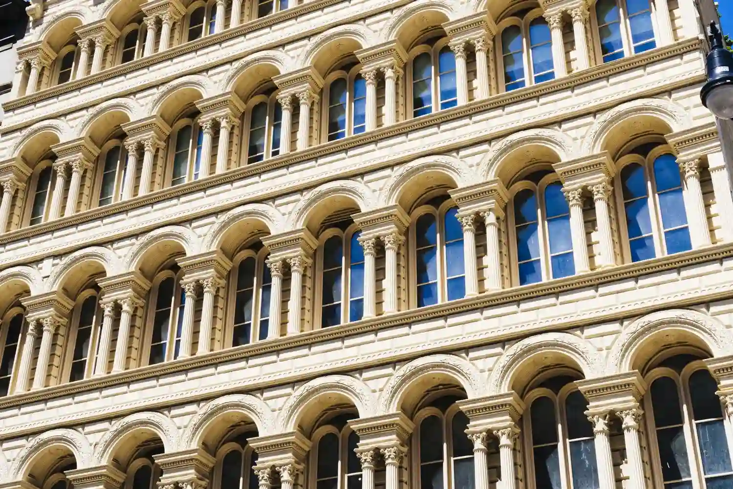 Деталізований фасад у класичному стилі з колонами та арочними вікнами, що ілюструє велич та естетику елітної нерухомості на Французькому бульварі