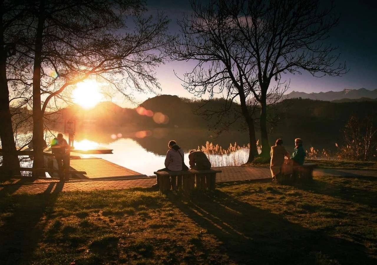 Люди відпочивають біля озера на заході сонця &mdash; весняний відпочинок за містом на природі