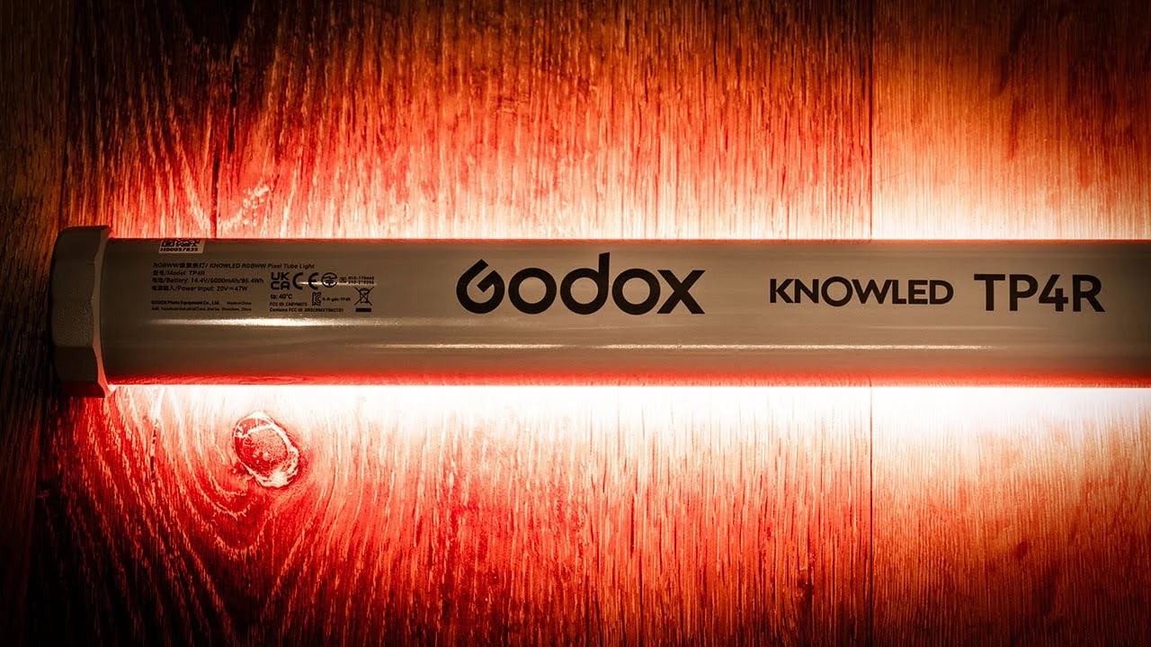 Технічна етикетка на корпусі Godox KNOWLED TP4R з даними про модель, напругу живлення 14,4V, ємність акумулятора 6000mAh і сертифікати UKCA, CE та FCC, підсвічена червоним світлом самого приладу.
