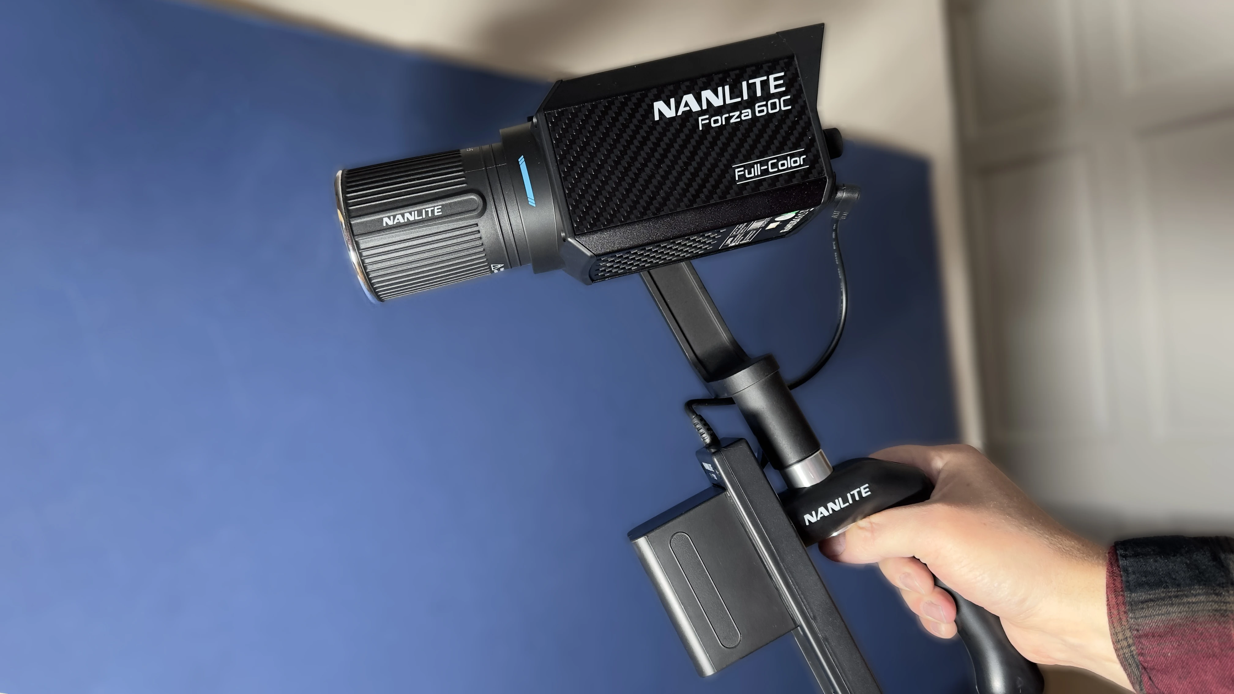 Портативний моноблок Nanlite Forza 60C у карбоновому корпусі на батарейній рукоятці із фірмовим кріпленням FM Mount під час портативної зйомки