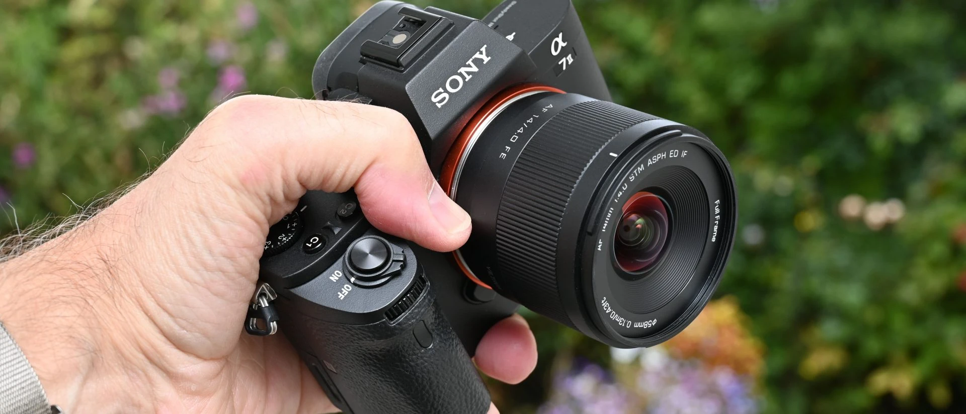Компактний повнокадровий об'єктив Viltrox AF 14mm f/4.0 Air FE на тушці бездзеркальної камери Sony A7, крупний план передньої лінзи та чорного корпусу.
