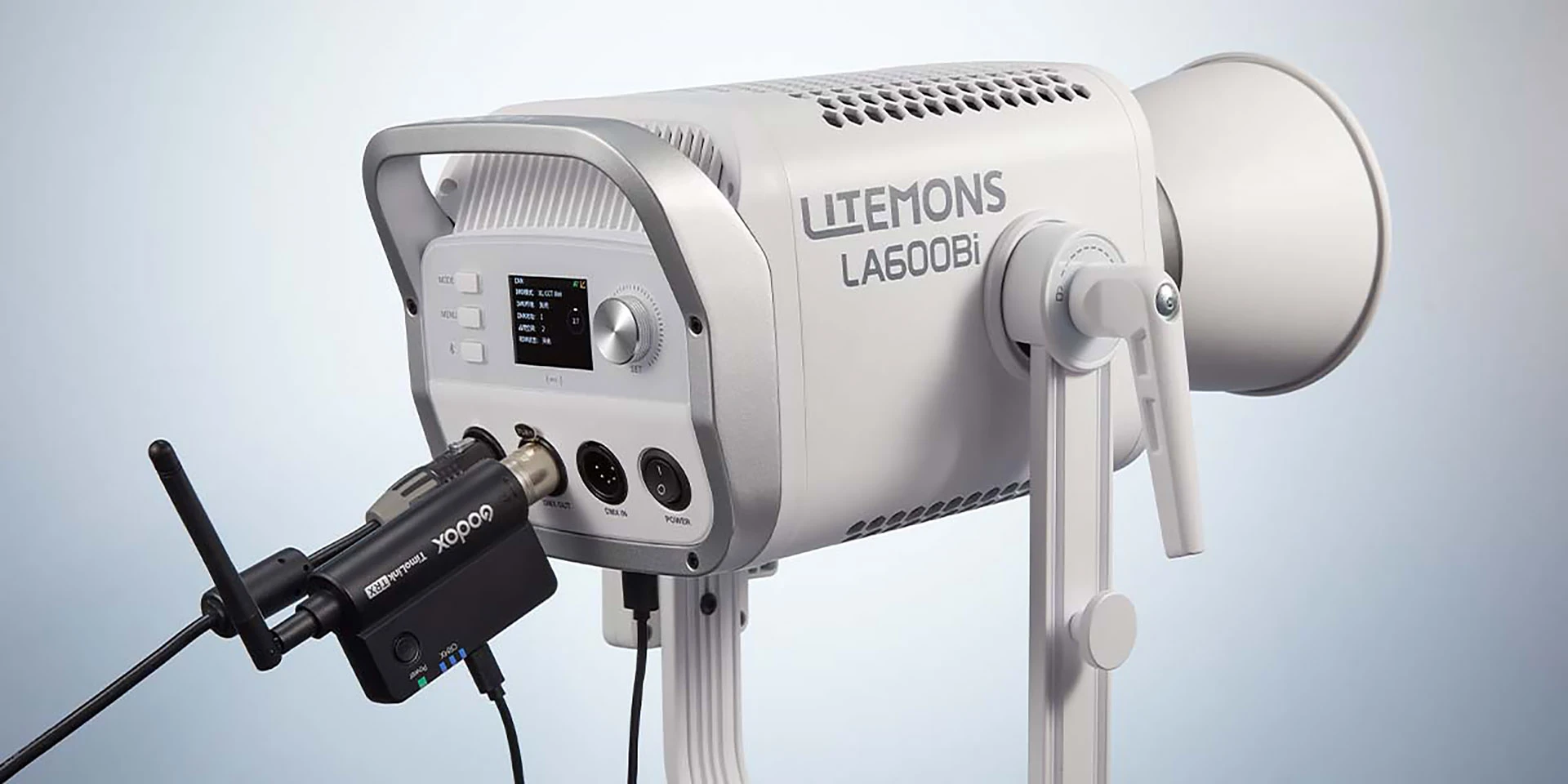 Білий корпус моноблока Godox Litemons LA600Bi на U-подібній лірі з панеллю керування та підключеним модулем TimoLink TRX