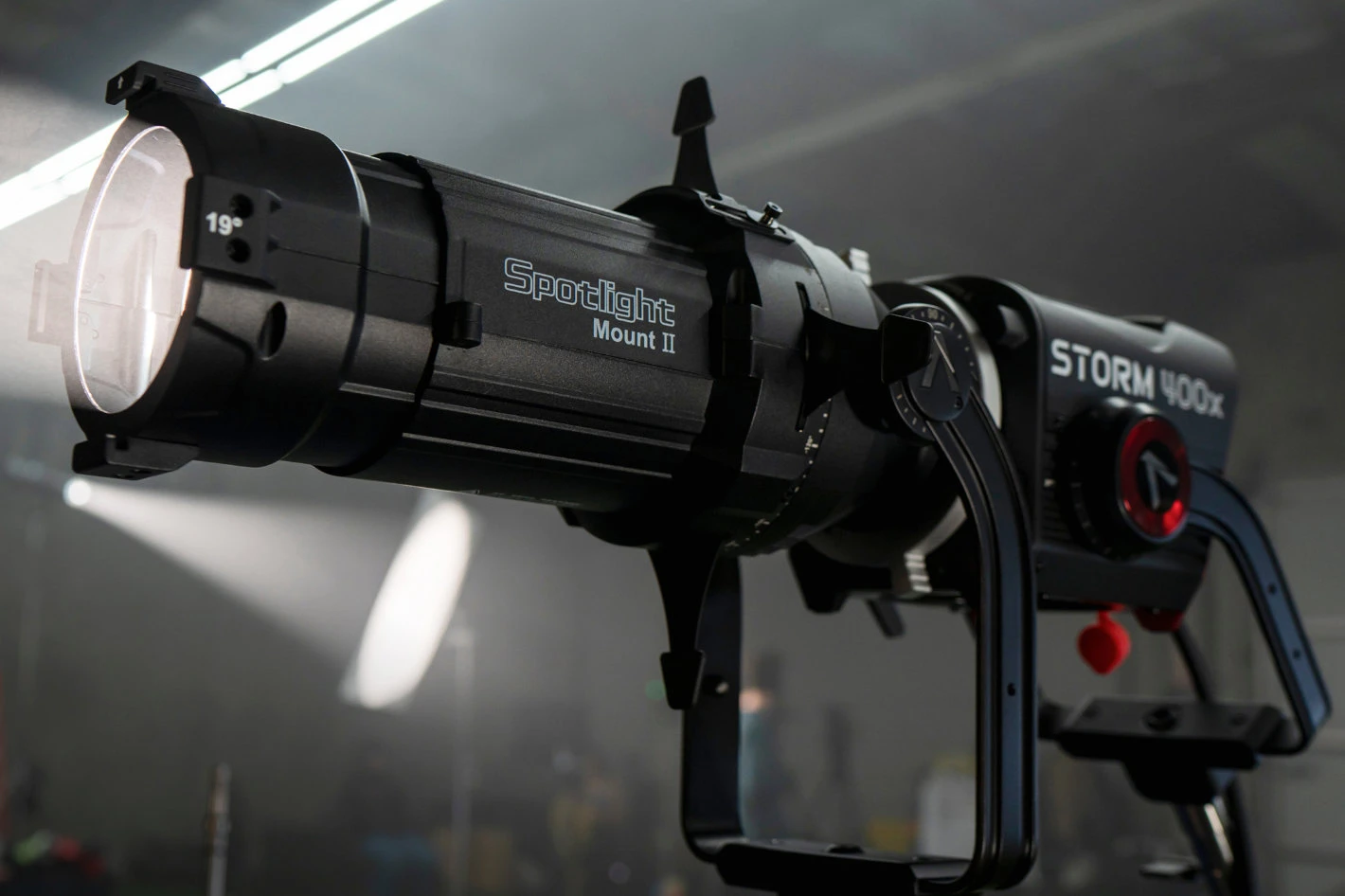 Моноблок Aputure STORM 400x з проекційною насадкою Spotlight Mount II 19 градусів створює чіткий світловий промінь у задимленому кінопавільйоні