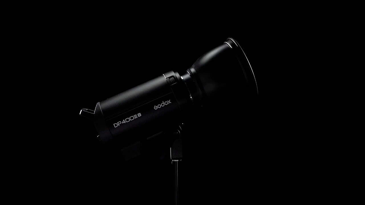 Моноблок Godox DP400III-V з бічним маркуванням закріплений на студійній стійці зі стандартним конічним рефлектором у напівтемній студії