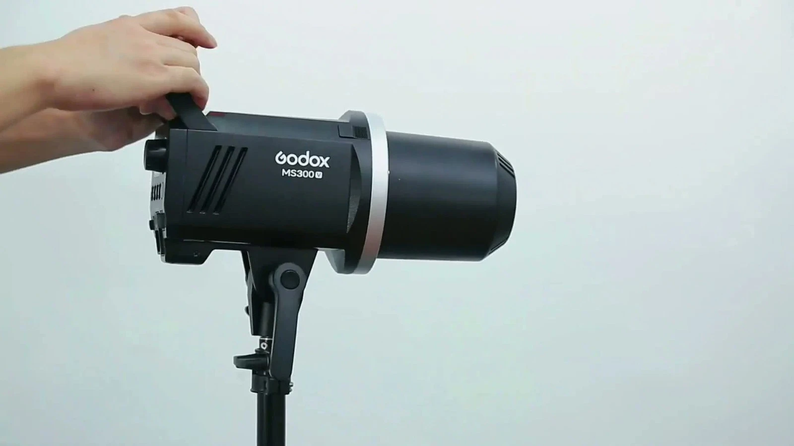 Моноблок Godox MS300-V у профіль із захисним пластиковим ковпаком для безпечного транспортування в руці фотографа