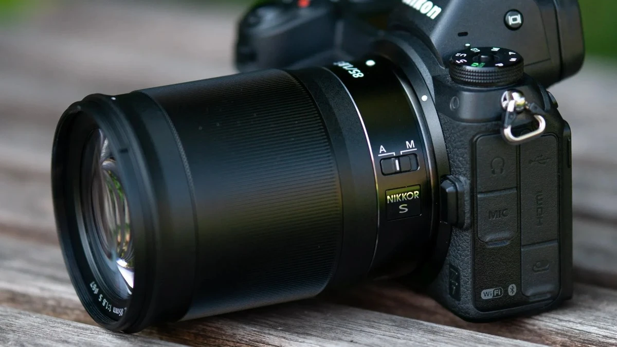 Об'єктив Nikkor Z 85mm f/1.8 S на повнокадровій камері Nikon Z 7 на дерев'яній поверхні на фоні м'якого природного боке