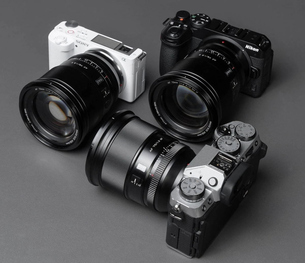 Три об'єктиви Viltrox AF 75mm f/1.2 Pro під різні байонети, версія Z-mount встановлена на чорну камеру Nikon Z 30 на сірому студійному фоні