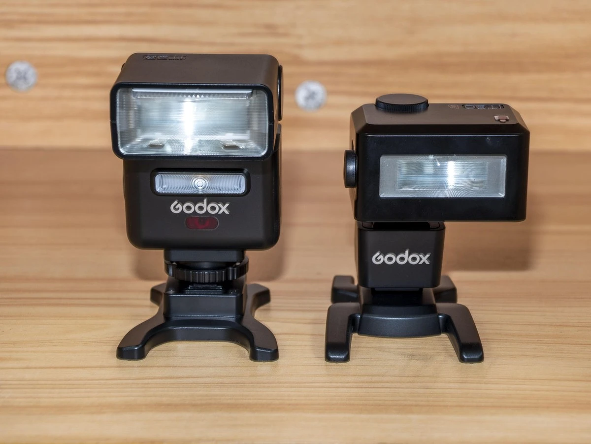 Миниатюрная вспышка Godox iT32, установленная на горячий башмак беззеркальной камеры в компактном сетапе