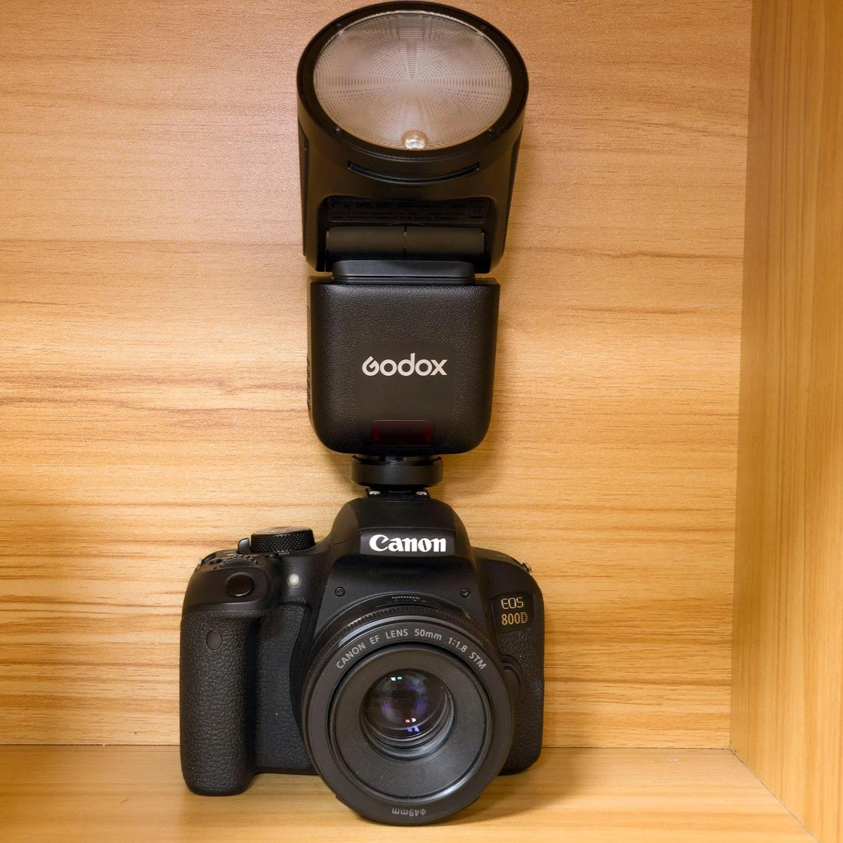 Вид сбоку на вспышку Godox V1mid с откинутой на 90 градусов поворотной головкой и замком горячего башмака