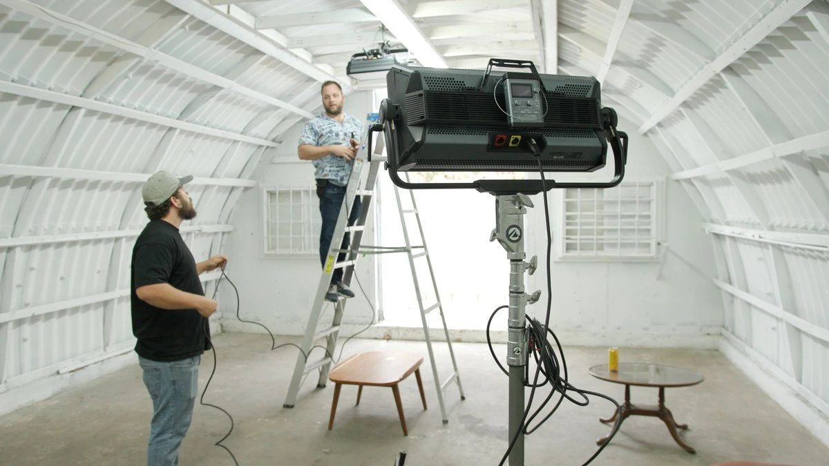 Задня панель кінопанелі Aputure Nova P600c на стійці Matthews у просторому павільйоні зі швидкознімним пультом керування та кабельними підключеннями