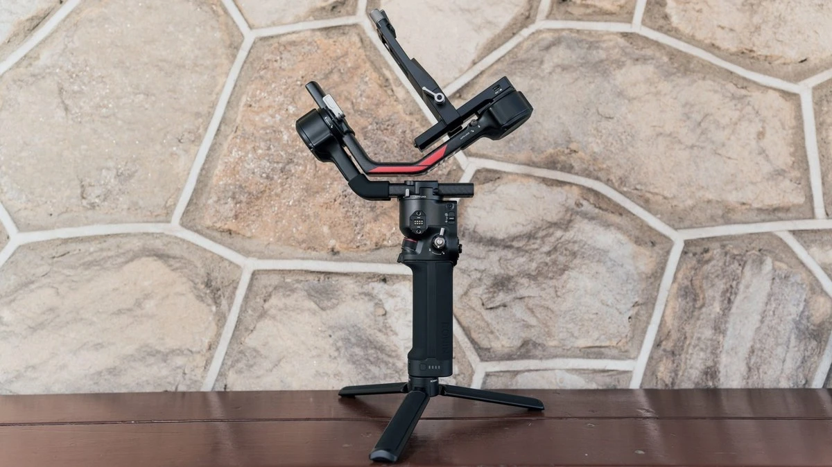 Стабілізатор DJI RS 4 у складеному стані з автоблокуванням осей на тлі світлої кам'яної кладки