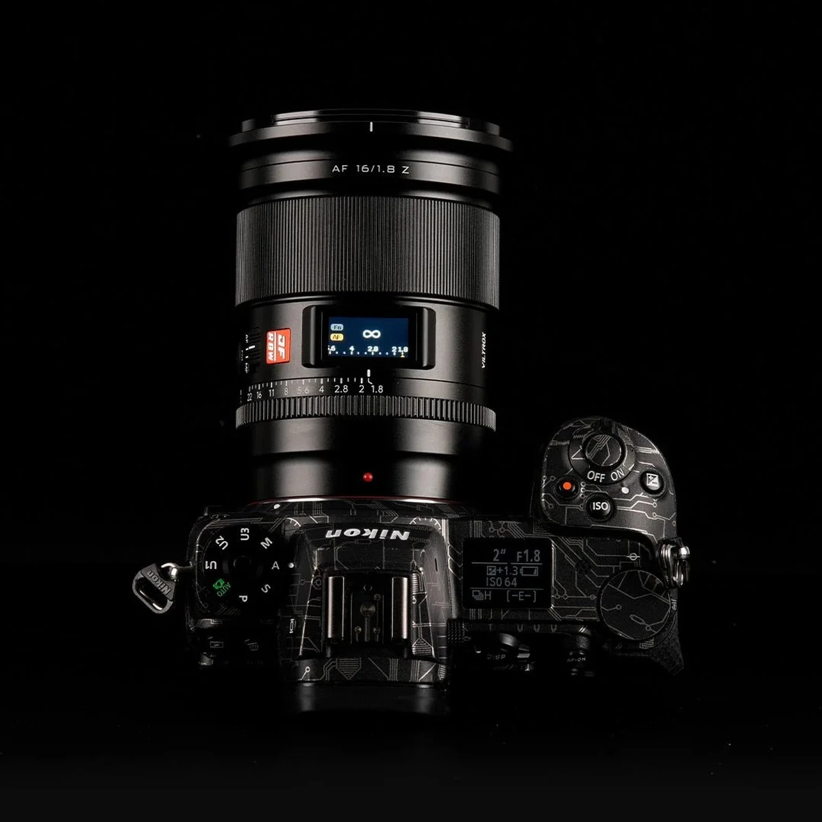 Объектив Viltrox AF 16mm f/1.8 Z на камере Nikon Z, верхний цветной IPS-дисплей отображает шкалу ГРИП и бесконечность рядом с механическим кольцом диафрагмы.