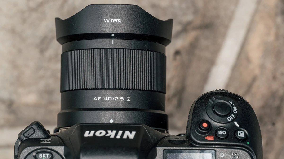 Объектив Viltrox AF 40mm f/2.5 Z с блендой на байонете камеры Nikon Z, видны верхние элементы управления и кнопка видеозаписи.
