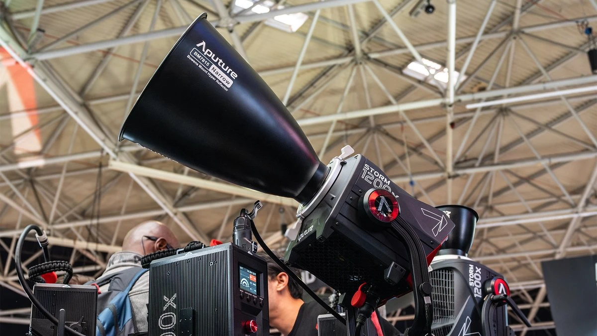 Моноблок Aputure STORM 1200x на високій стійці з вузькокутним рефлектором та блоком управління у виставковому павільйоні