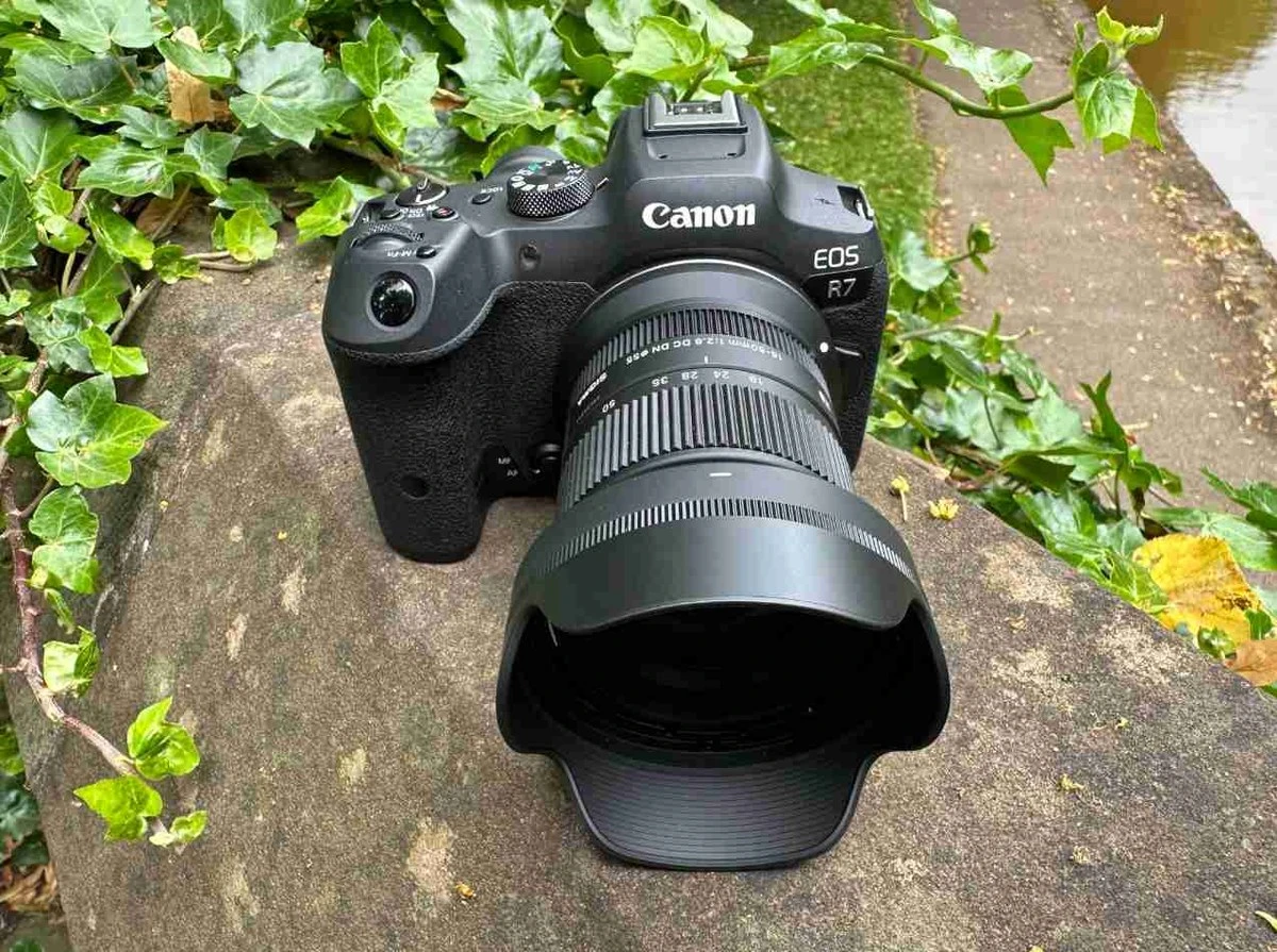 Об'єктив Sigma 18-50mm f2.8 DC DN Contemporary на камері Canon EOS R7 на кам'яному парапеті біля води