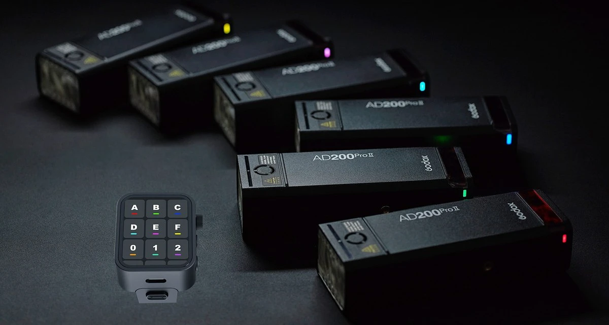 Шість спалахів Godox AD200Pro II з кольоровими світлодіодними індикаторами груп на студійному столі в низькому ключі поруч із тригером Godox X3