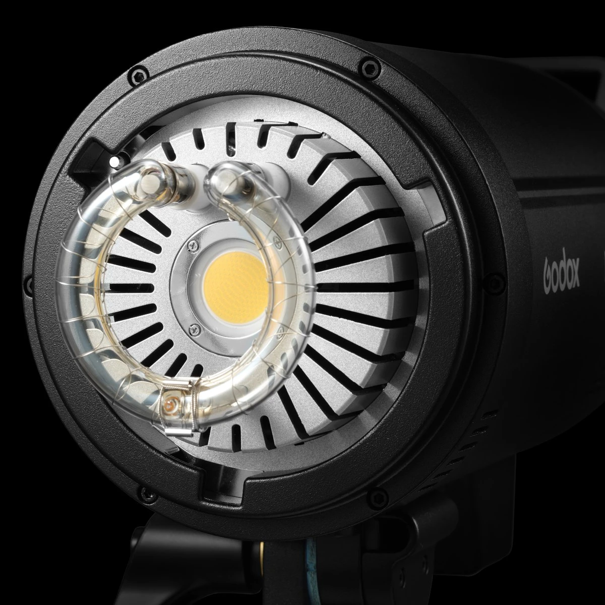 Передня частина моноблока Godox DP400III-V на темному тлі з відкритою кільцевою скляною імпульсною лампою, матрицею 30W COB LED пілотного світла, радіатором охолодження та байонетом Bowens