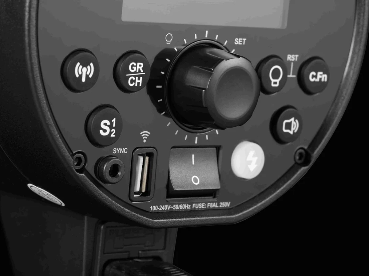 Панель управління моноблока Godox DP400III-V на темному тлі, велике коліщатко регулювання SET, клавіші вибору груп та каналів, синхророз'єм, кнопка живлення та маркування запобіжника F8AL