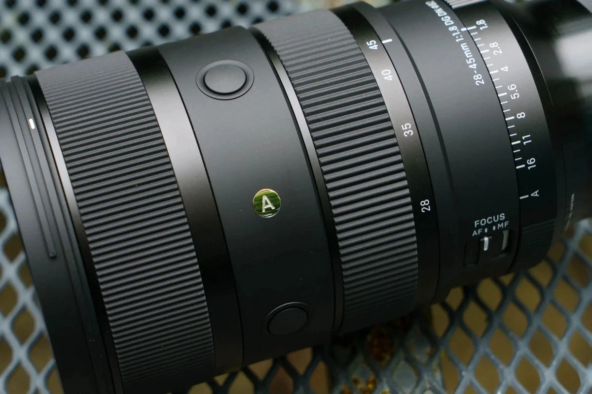 Крупный план тубуса Sigma 28-45mm f/1.8 с кнопками AFL, переключателем фокуса и кольцом диафрагмы