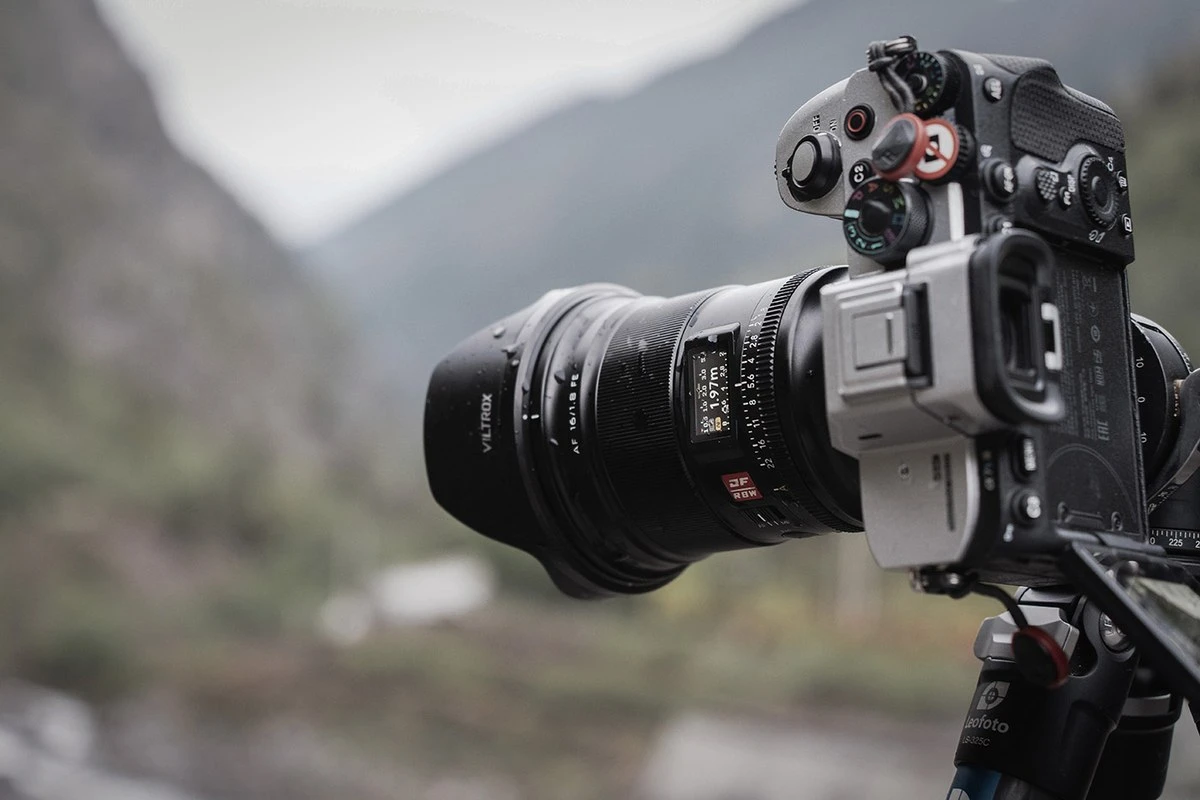 Об'єктив Viltrox AF 16mm f1.8 FE з краплями дощу на металевому корпусі на штативі Leofoto