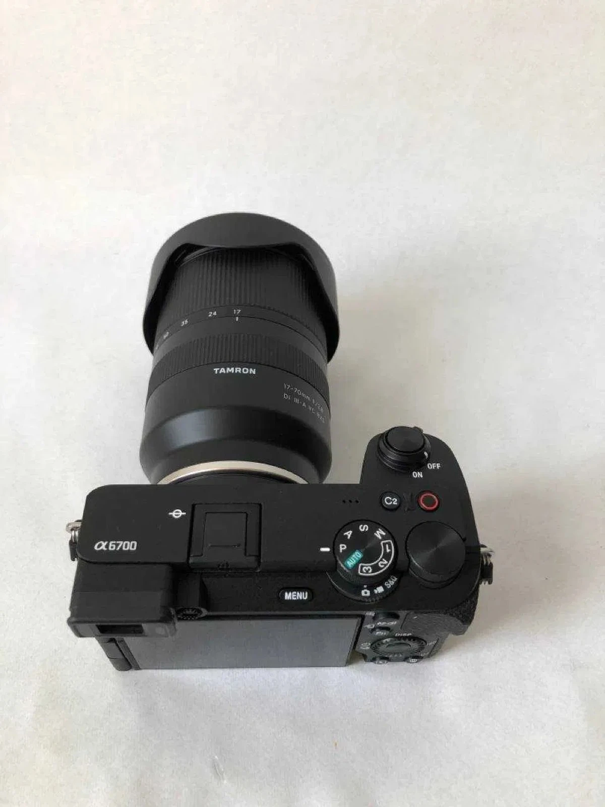 Камера Sony a6700 зі встановленим довгим зумом Tamron 17-70mm f/2.8 на студійному білому тлі
