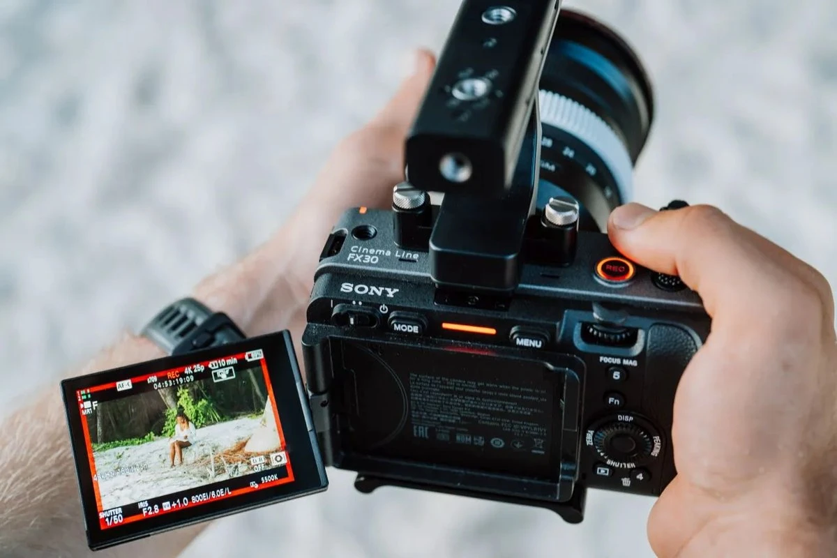 Задня панель камери Sony FX30 з поворотним РК-екраном у режимі моніторингу Cine EI на пляжі