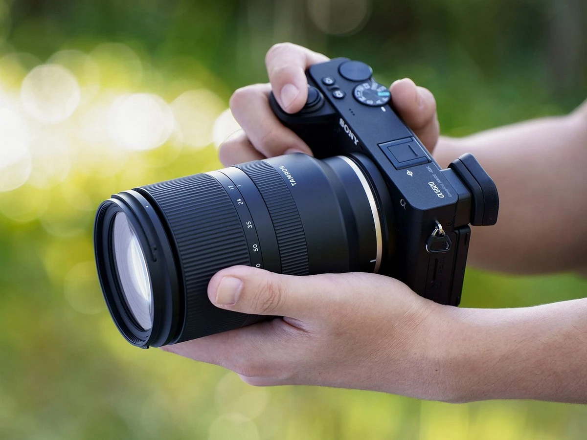 Дворучний хват масивного об'єктива Tamron 17-70mm f/2.8 Di III-A VC RXD на камері Sony: помітні великий діаметр корпусу, довгий тубус і перекіс балансу зв'язки вперед