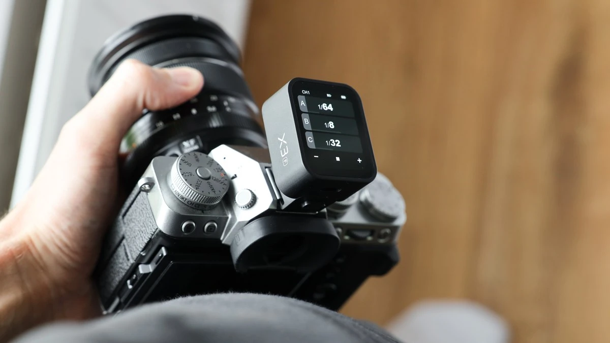 Синхронизатор Godox X3 версии для Fujifilm в горячем башмаке камеры Fujifilm: на OLED-экране видны канал CH1 и мощности групп A, B и C