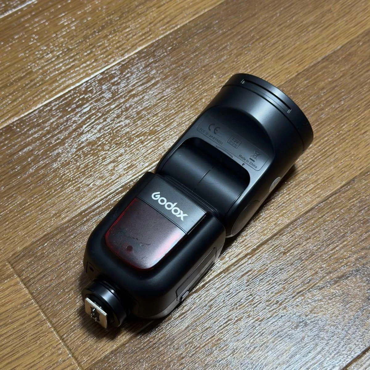 Металевий гарячий башмак ISO на корпусі Godox V1C для камер Canon, з класичним круглим швидкозатискним важелем-фіксатором та червоним вікном підсвічування автофокусу