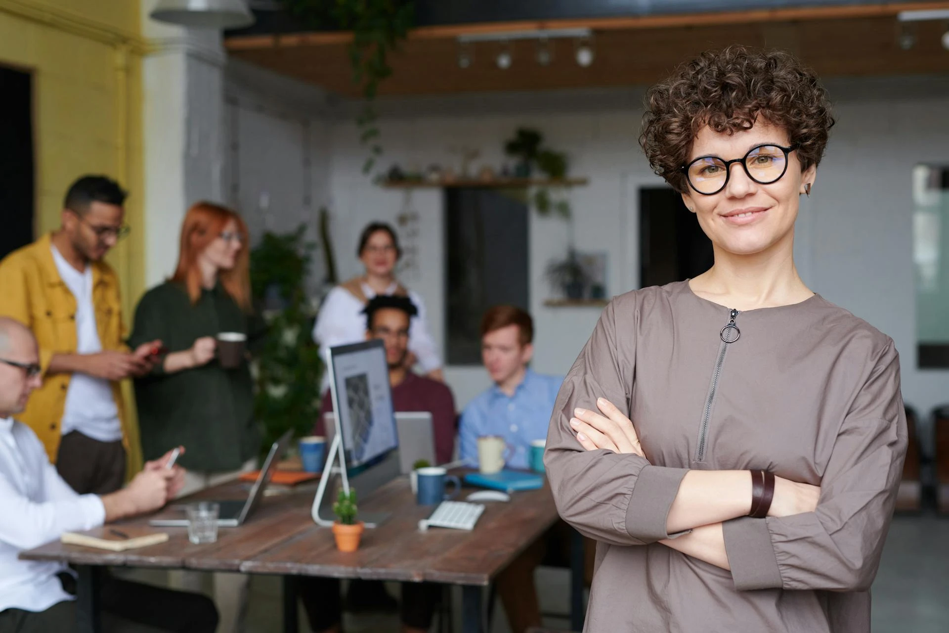 A web designer stands infront of their team as they are planning a strategy.