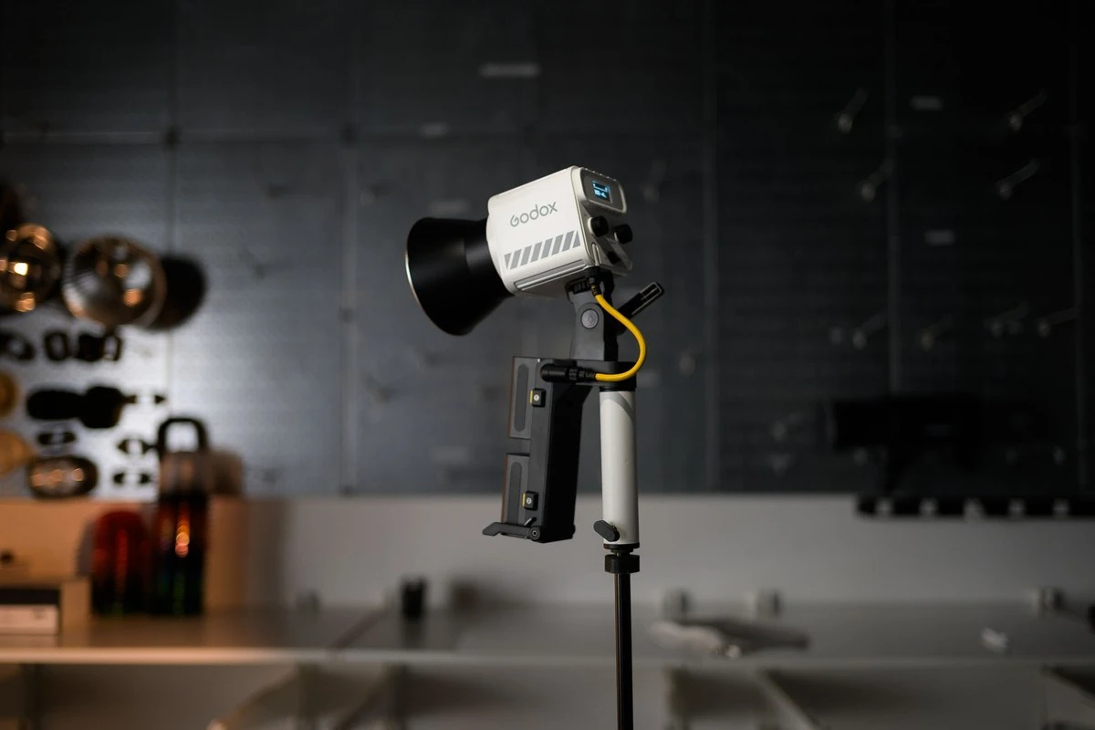 Світильник Godox ML60II Bi з компактним рефлектором на високій студійній стійці з рукояткою AK-B01 та двома встановленими акумуляторами NP-F