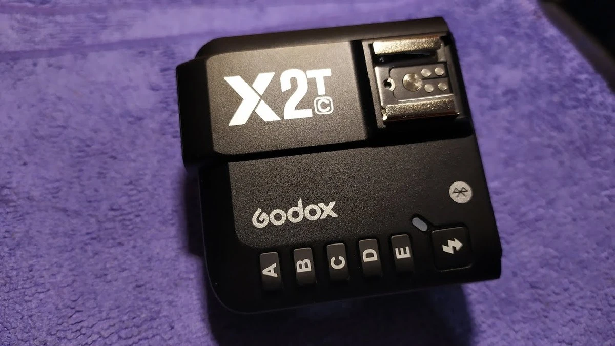 Верхня панель синхронізатора Godox X2T-C з виділеними клавішами вибору груп A, B, C, D, E та металевим гніздом верхнього башмака