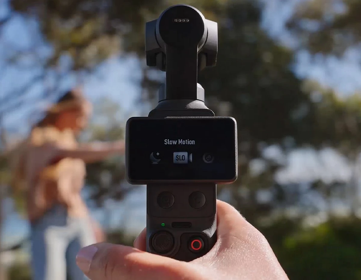Камера DJI Osmo Pocket 4 з розвернутим сенсорним екраном у меню режимів Slow Motion, трьома осями підвісу та контактними точками живлення