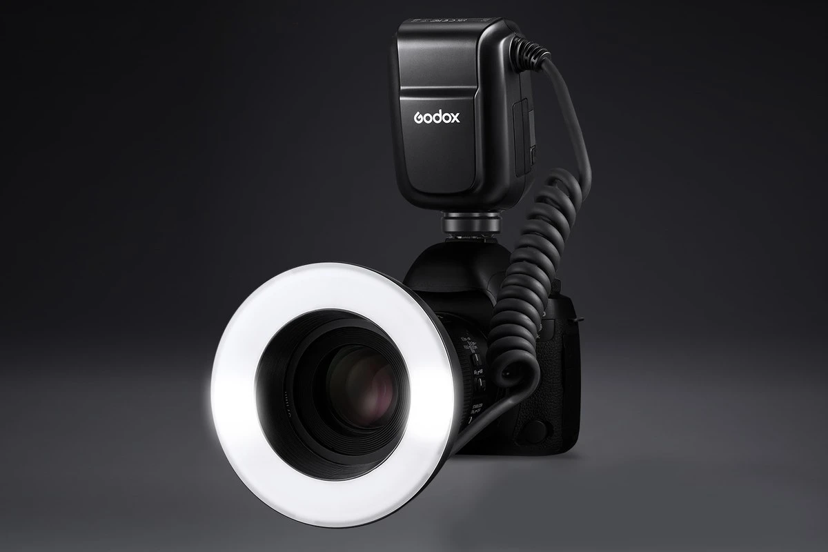 Кільцевий макроспалах Godox MF-R76C на об'єктиві фотокамери з увімкненим круговим дифузором та блоком контролера
