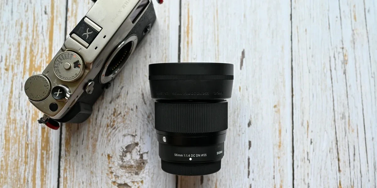 Об'єктив Sigma 56mm f/1.4 DC DN Contemporary з блендою поруч із камерою Fujifilm
