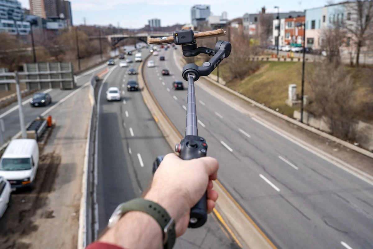 Удлинённая штанга стабилизатора DJI Osmo Mobile 7P поднимает смартфон над дорогой